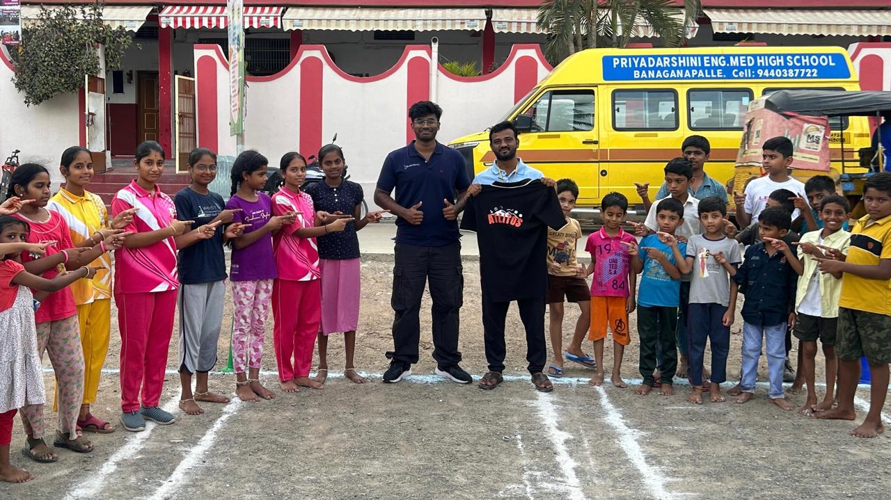 Atlitos Community Outreach - Team members with children at school sports program